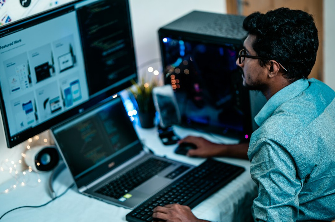 person coding on laptop at desk